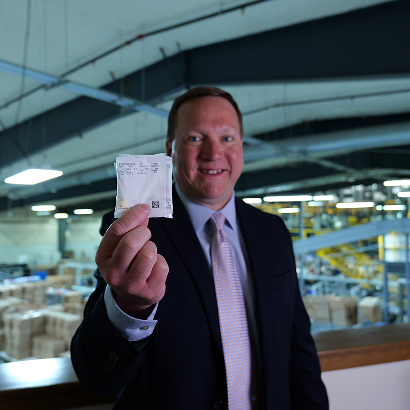 optics team member holding medication packet